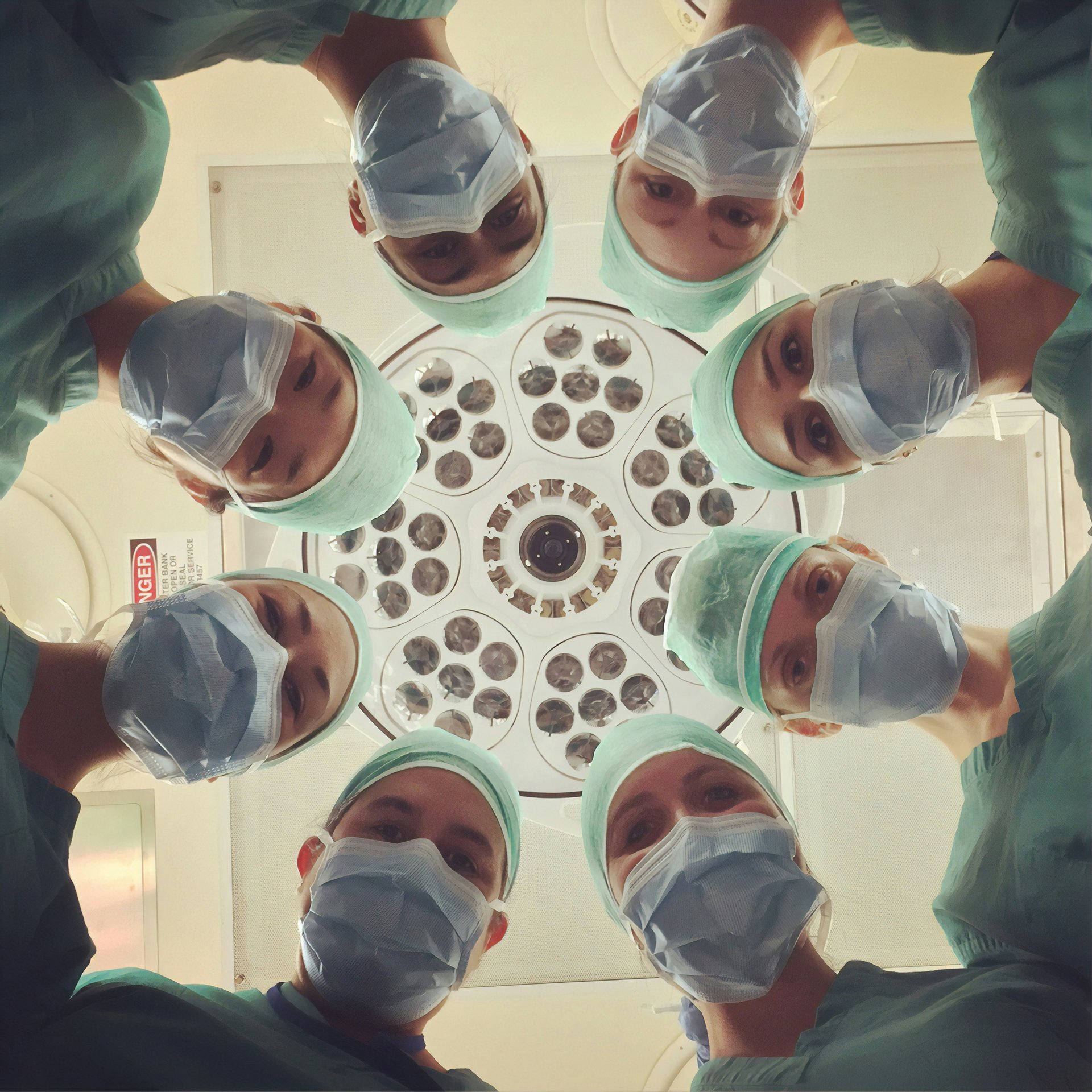 Surgical team gathered together under operating room lights